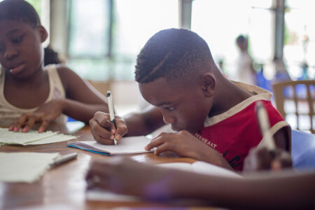 Niño escribiendo en un papel